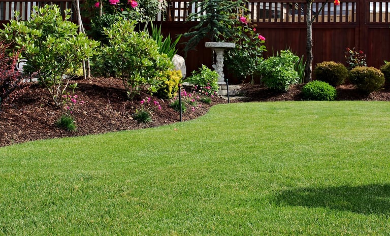 Freshly mowed garden lawn grass area surrounded by flowerbeds